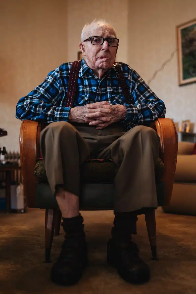 man wearing brown trousers sitting on sofa chair